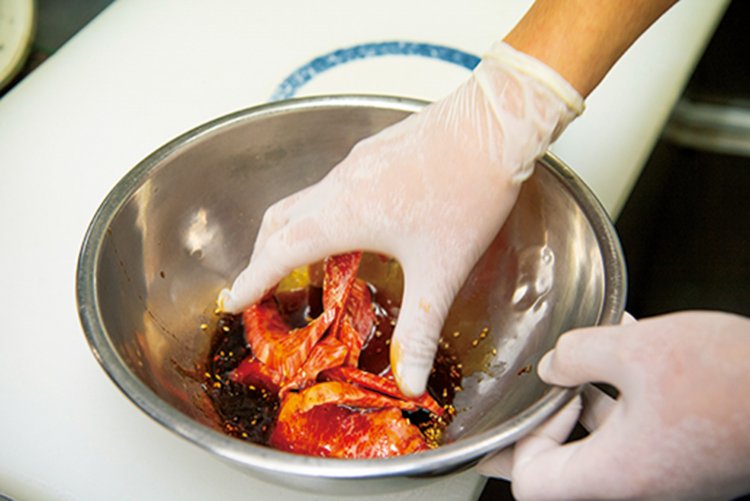 カルビにタレをなじませる確かな手つき。