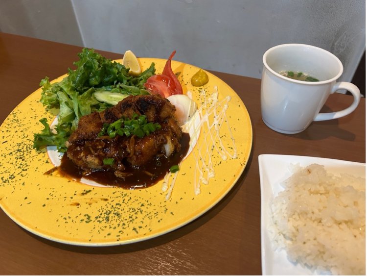 黄色い皿にのったポークカツレツは、見た目にも美しい。