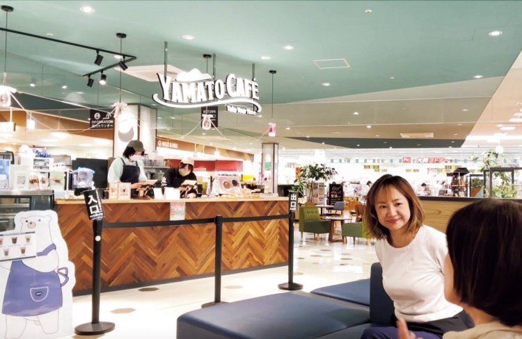 奥はスーパー、周りの専門店ともフラットにつながるカフェエリア。