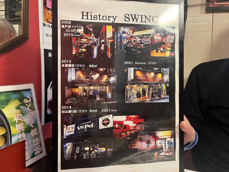 店の歴史を見せてくれた店長の岡野さん。