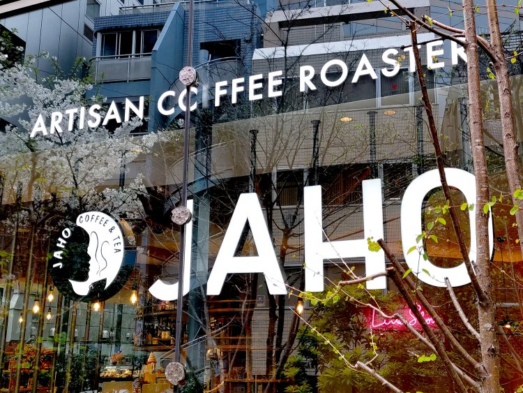 通りに面したガラス張りの壁に、店舗のスタイリッシュなロゴがあしらわれている。