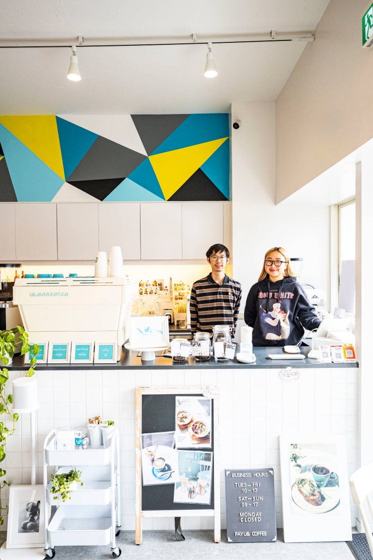 インドネシア人の母娘が営む『PAYU & COFFEE』店内。娘のアリファさん（右）とスタッフのジェイさん。壁画は母のニンさんがデザイン。