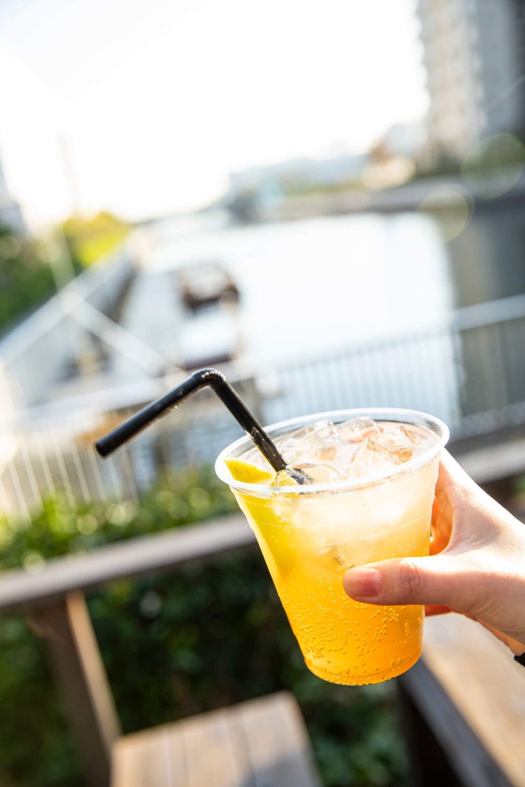 『CONTAINER CAFE 2187』のドリンク（自家製レモネード400円）とウッドデッキの景色。