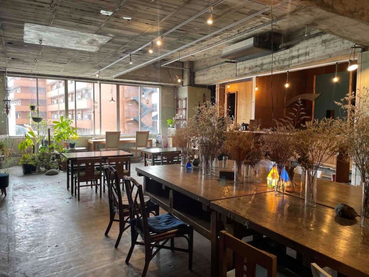 建物は1964年築の高層集合住宅。カフェだけで108平方メートルの広さ。学校の図工室の大机などが座席に使われる（写真提供＝BUoY Cafe）。