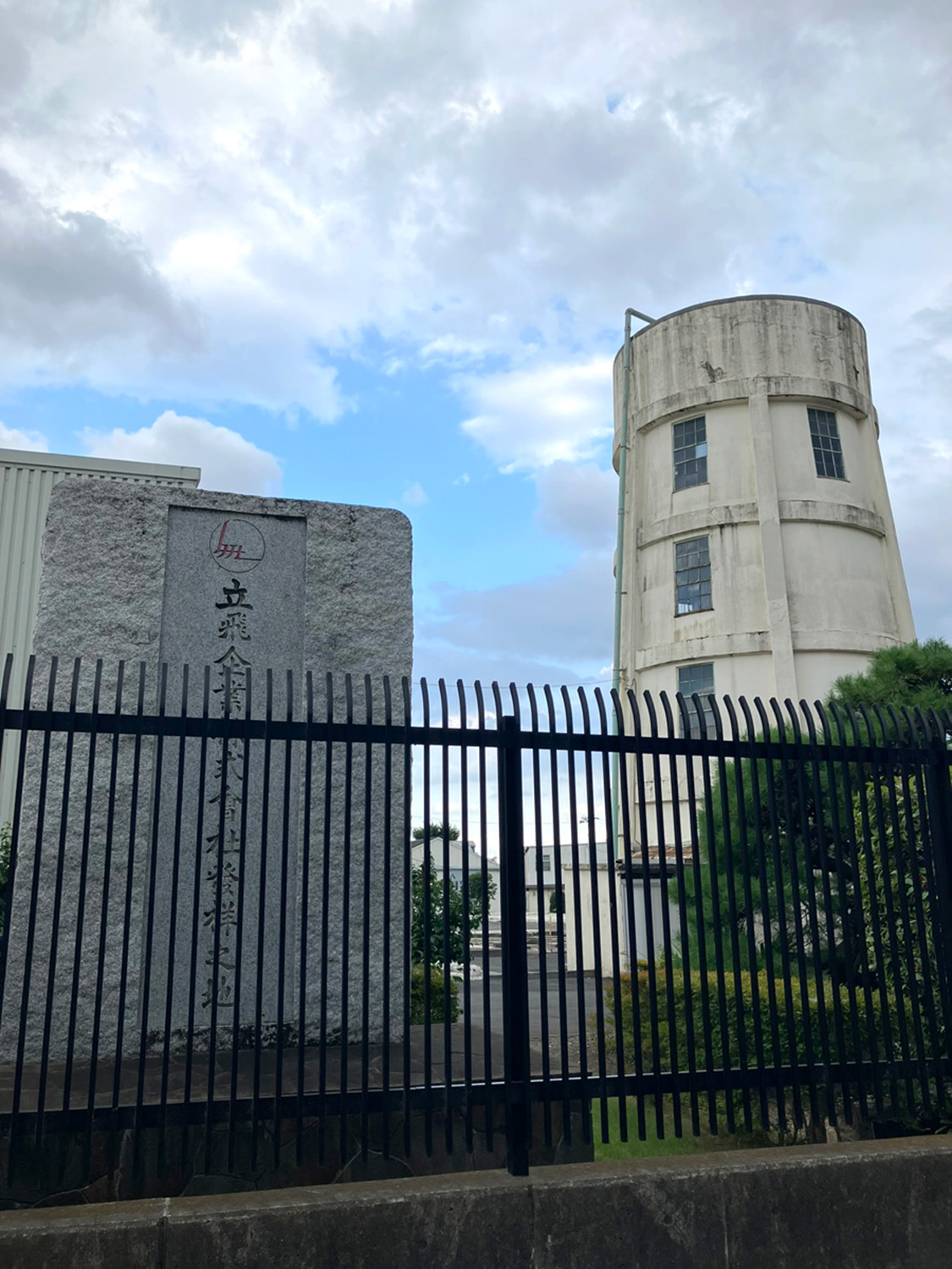 現在は「立飛ホールディングス」敷地内に設置されている記念碑。右に写る給水塔は昭和13（1938）年に建てられたとのことで、歴史を感じさせる。