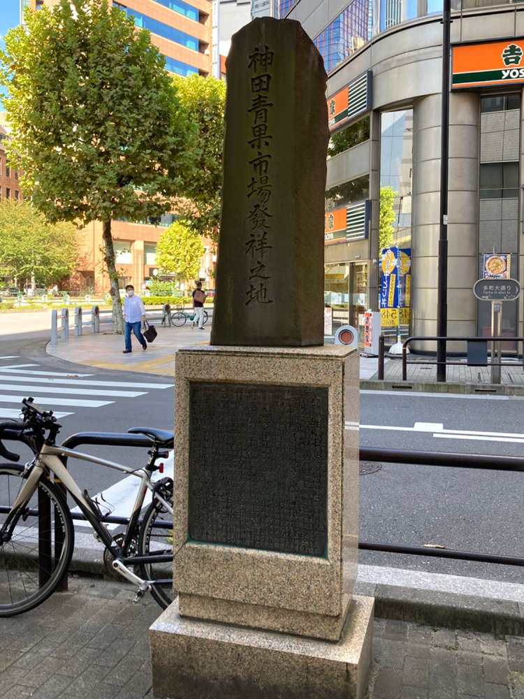 神田・淡路町交差点近くに建てられている、「神田青果市場発祥の地」碑。江戸時代、明暦の大火以降にこの周囲に青物市が集まってきたとのこと。