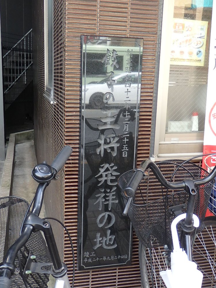 普段は気にも留めず自転車置き場にされてしまいがちだが、改めて餃子の王将発祥の地というすごさを感じたい。