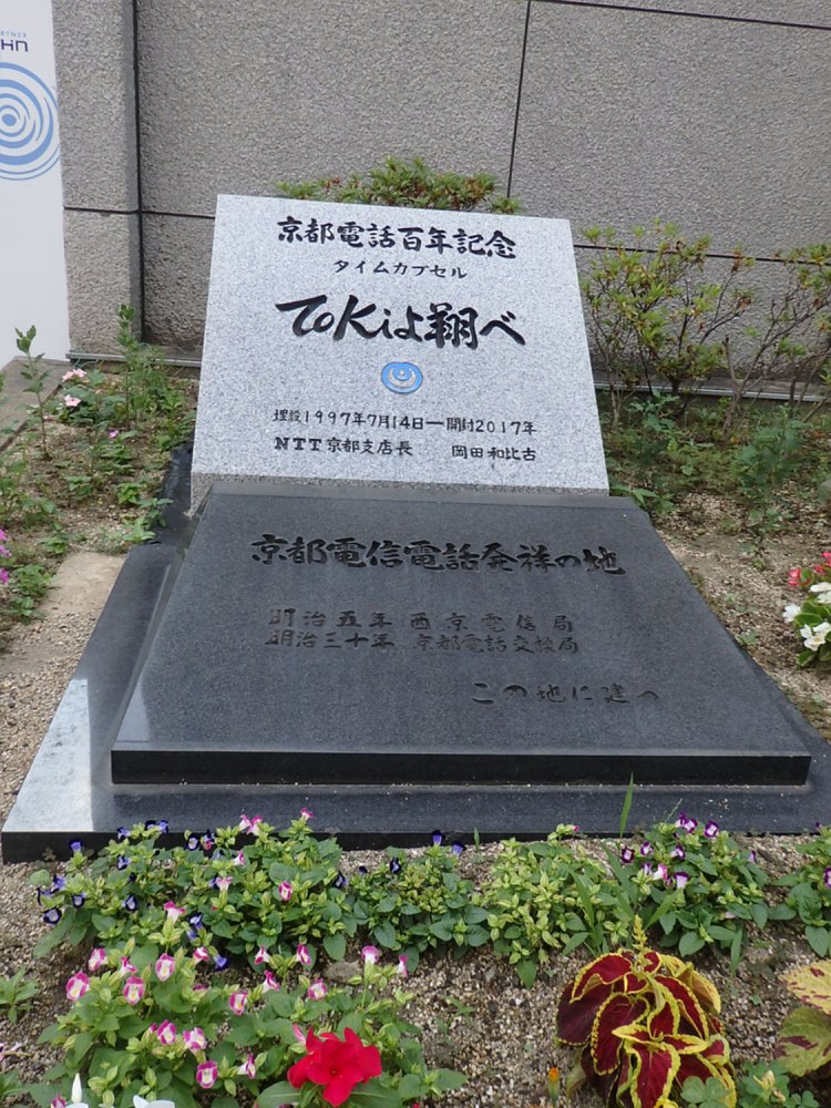 京都のNTT西日本の敷地内、道路に面したところに設置されている。タイムカプセルは開けられたのだろうか。