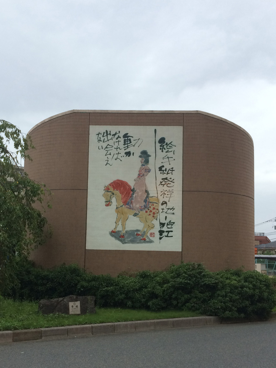 小田急線・狛江駅北口を出てすぐの排気塔に掲げられている。これを撮ったのは数年前だが、巨大絵手紙は現在新しいものに変更されている。