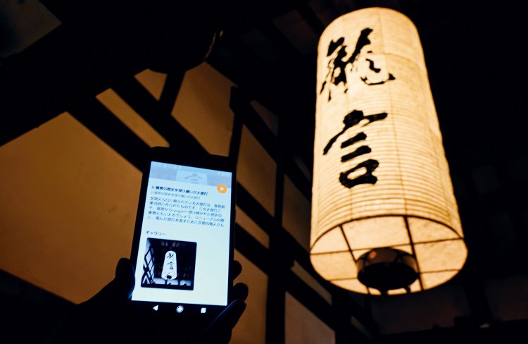 玄関入口の大提灯は創業当時のもの。スマホを貸し出して館内ツアーも。