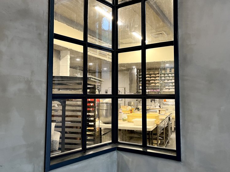 パンの陳列台の横にある窓からパンを仕込んでいる様子が見える。