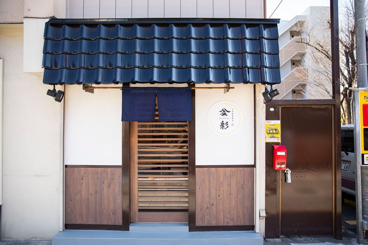 藍色の庇瓦（ひさしがわら）とのれんが目を引く、カウンター7席の店。2023年開店。