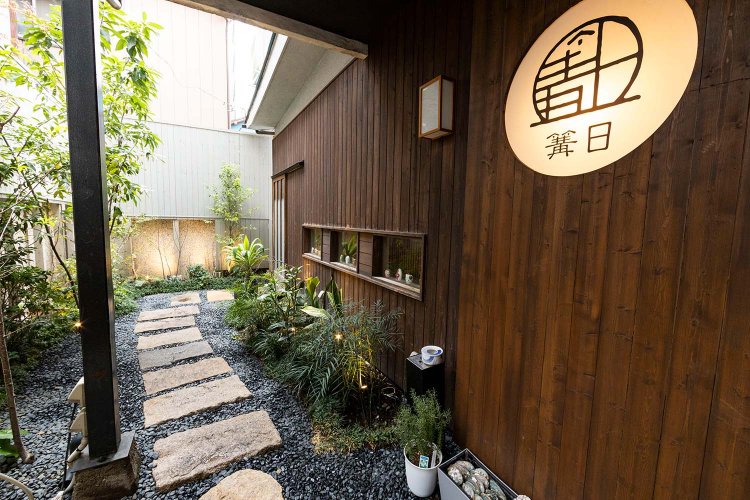 飛び石と植栽に導かれる玄関アプローチ。