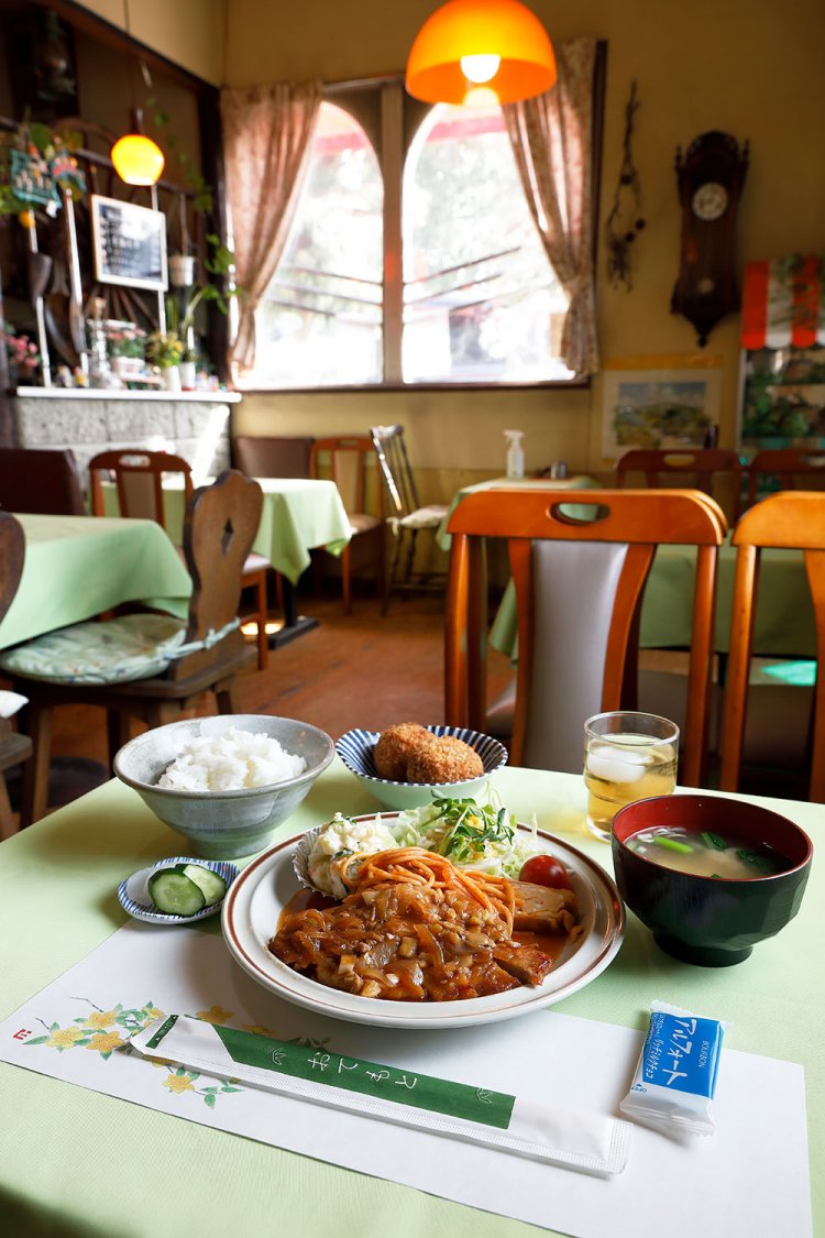 日替わり定食のポークソテー＆コロッケボール付き750円。お茶請けのお菓子もニクい。コーヒー、紅茶、ソーダ水から選べるドリンクセットは＋100円。
