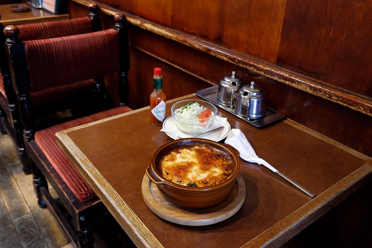 焼きチーズカレー900円はサラダ付き。タバスコで風味が一変する。