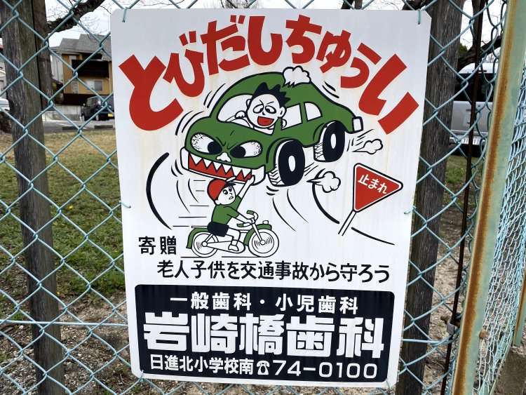 車の前を自転車で走り抜ける子供。