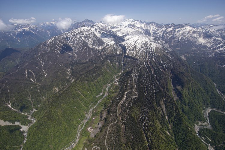 称名滝の先に室堂、立山が見える。その峰の向こう側には黒部ダムがある。