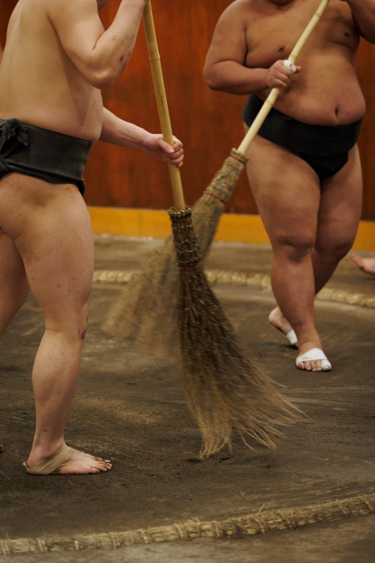 稽古中は力士たちがほうきで土俵を整える場面も。本場所では見られない光景。