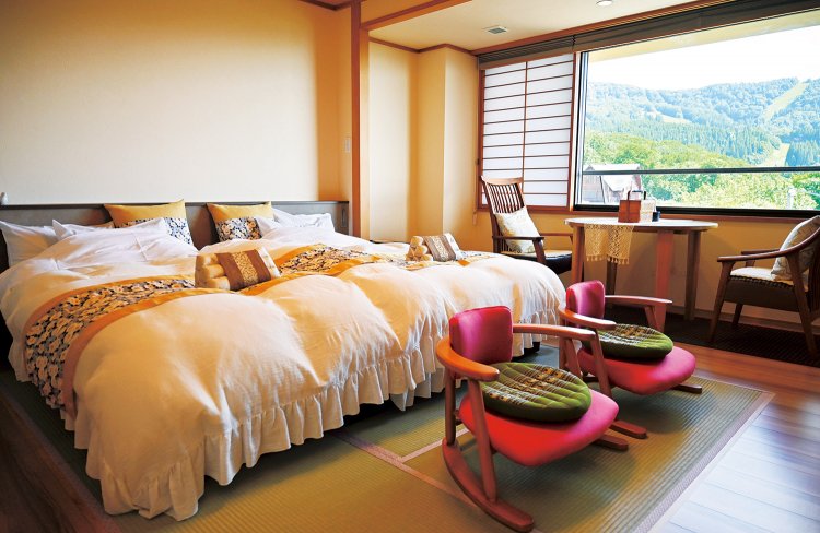 「ともしび」の客室。イスの上の座布団やクッション、ベッドライナーなどに女将のセンスが光る。