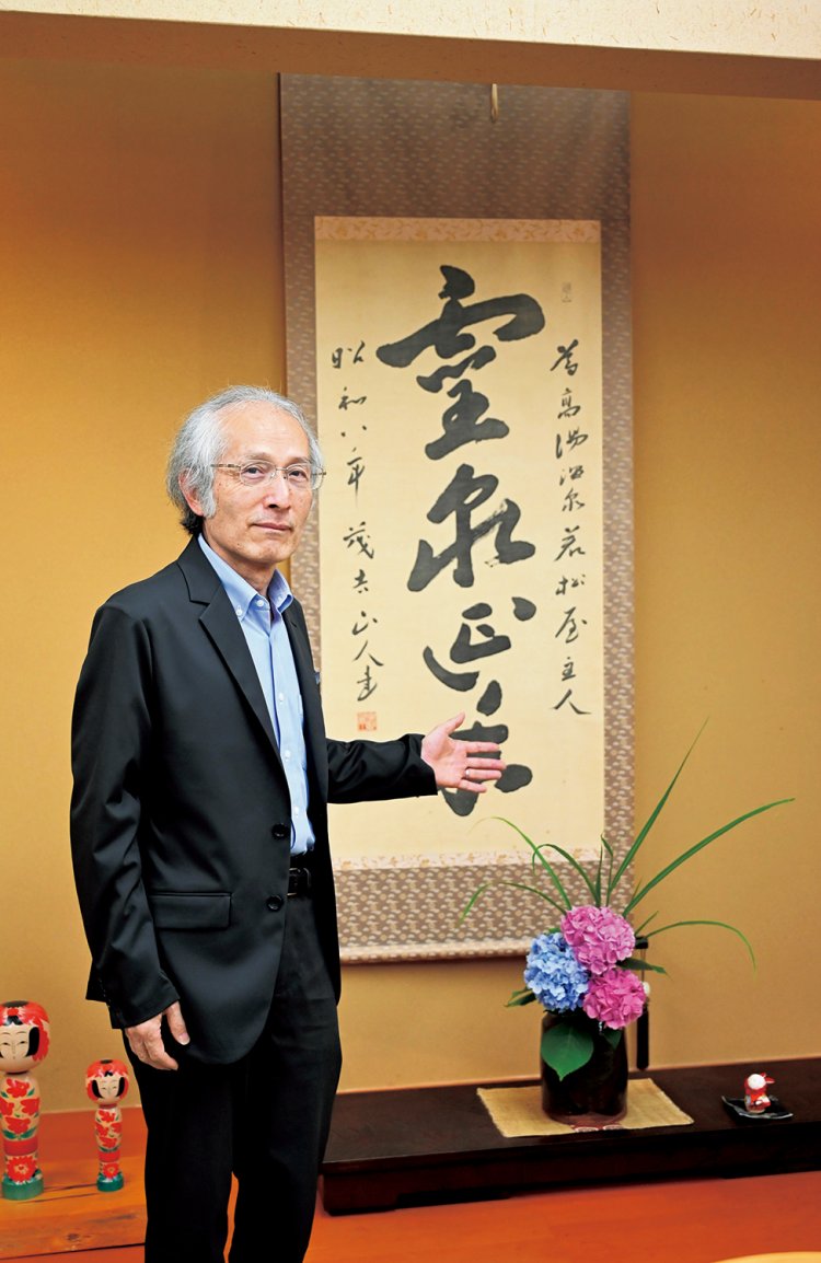 「万葉の間」にある茂吉が書いた「霊泉延年」の書（レプリカ）と13代当主。