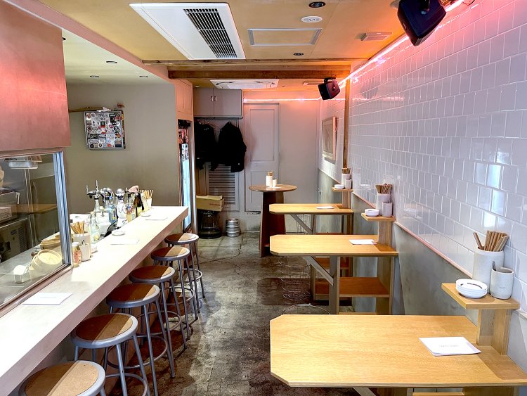 白いレンガに映るピンクのライトがネオ居酒屋っぽい。