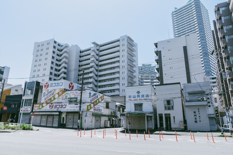 古い商店の後ろには、高いビルがおしせまるように立ち並ぶ。