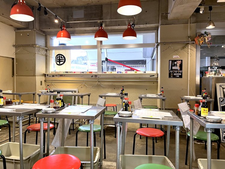 屋台のにぎやかな雰囲気がある店内。床には駐車場だった頃の白いラインがうっすら残っている。