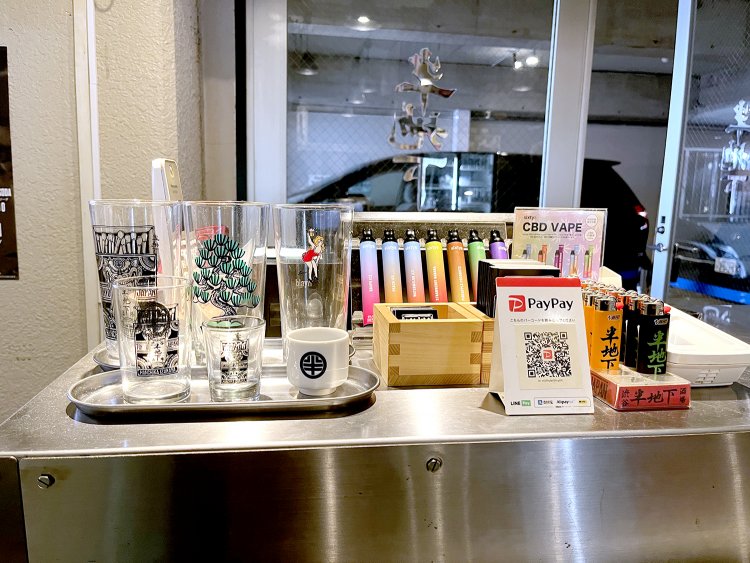 店を彩るグラフィックが描かれたタンブラーやTシャツなどを、レジ前で販売している。