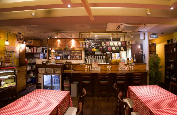 木の温もりを感じるインテリアとギンガムチェックのテーブルクロスがかわいらしい店内。