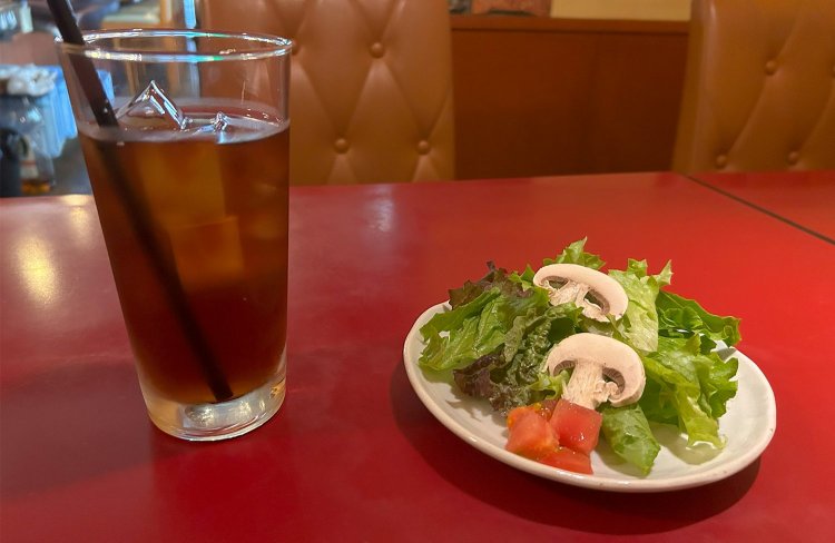 ランチメニューのサラダ・ドリンクセット220円。ドレッシングも手作りで、玉ねぎやレモンなどを使用している。