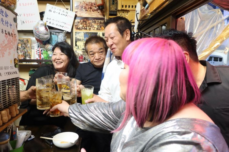 立ち飲み屋でぎゅうぎゅうの乾杯。うれしいよう、うれしいよう！