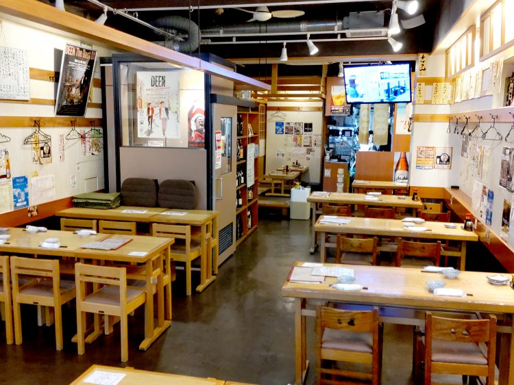 壁にびっしり貼られたメニューやポスターなどが大衆酒場っぽさを演出。店内中央には喫煙室も。