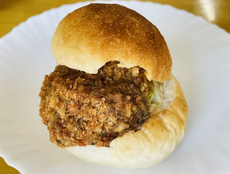 メンチバーガー324円。こぶしのような手作りメンチをかじると肉汁があふれる。