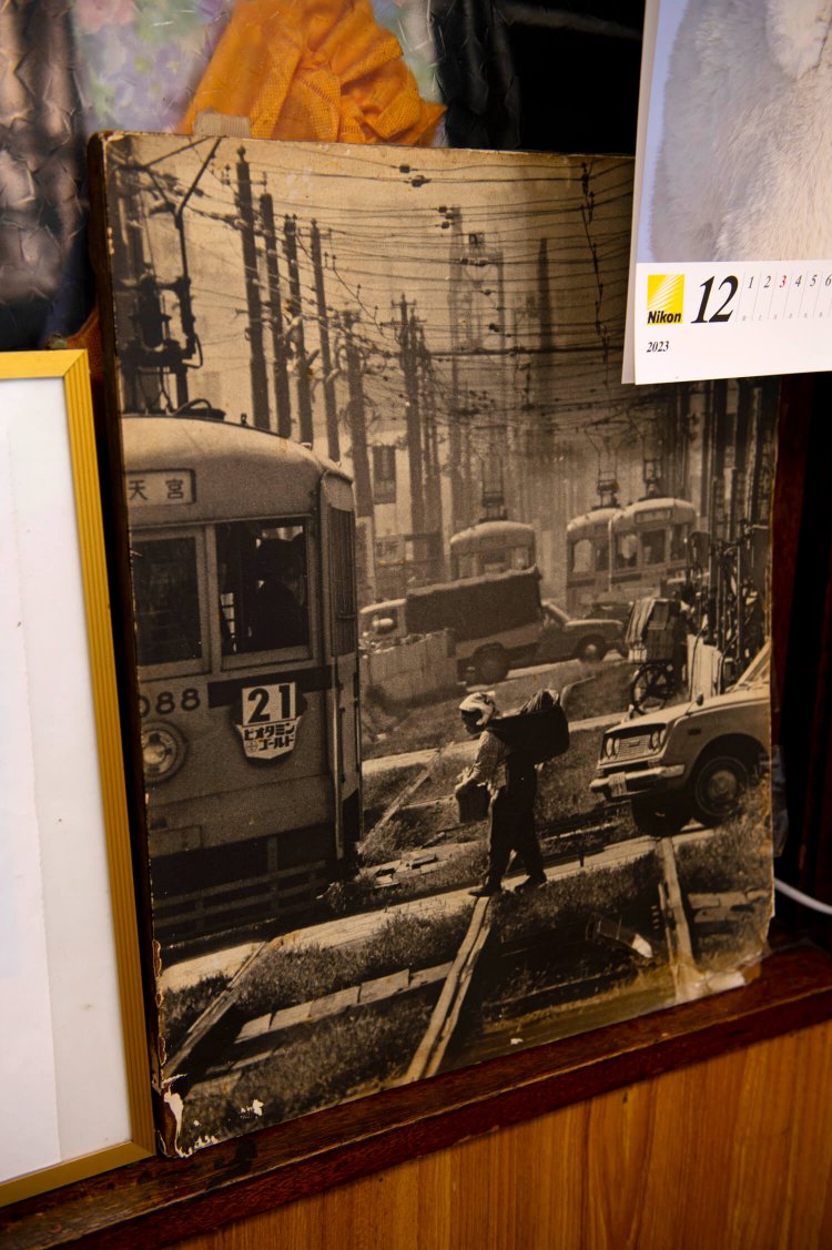店内に飾られた武雄さんの作品。都電と行商の女性が切り取られている。
