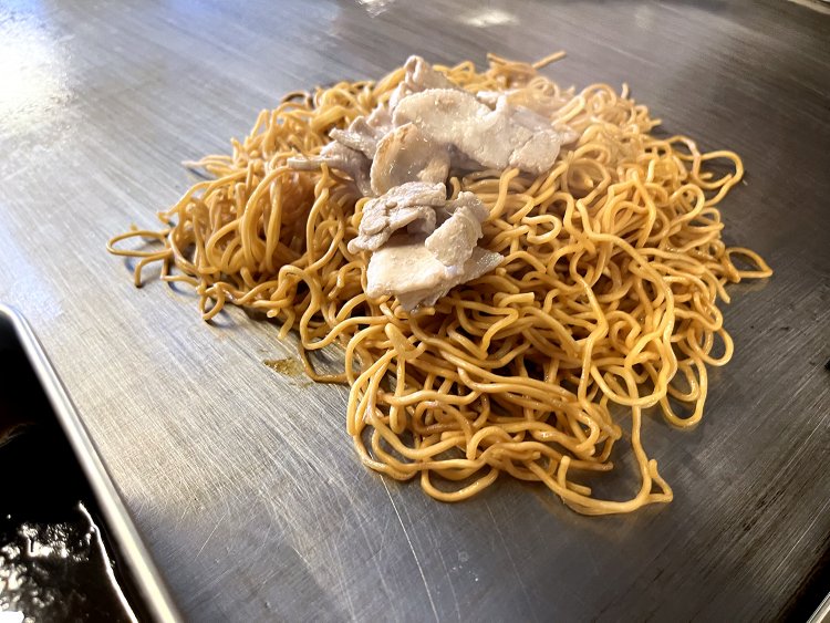 麺と並行して焼いていた豚バラと花ニラを合わせ、ソースで味付けて完成だ！