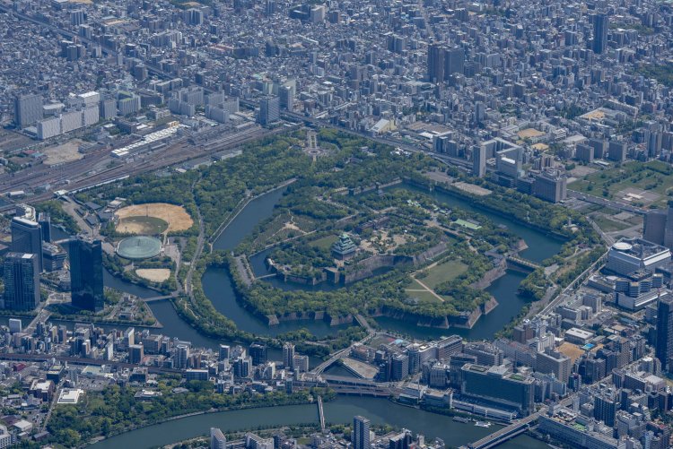 大川を手前にした北方向から望む。大川に注ぐ寝屋川には京橋が架かり、そのすぐ左手に旧化学分析場がある。左手の野球場や大阪城ホール一帯は兵器工場「造兵廠」だった。2021年5月3日撮影。