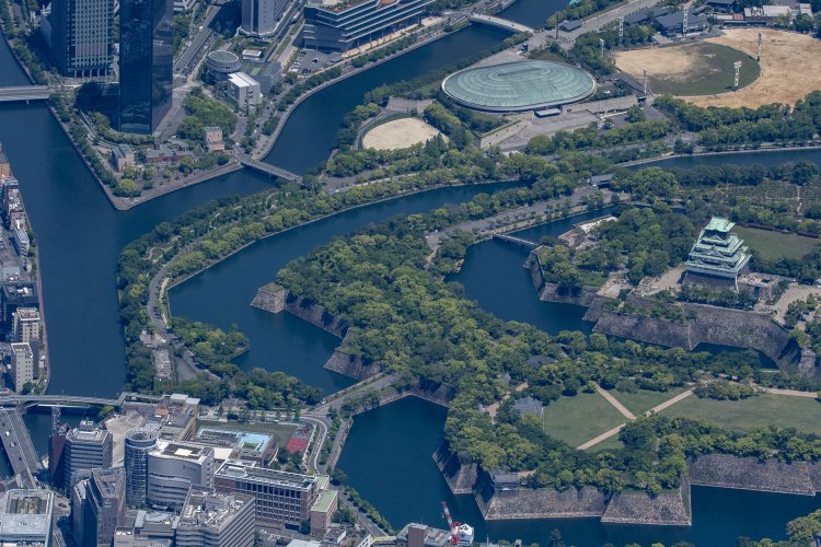 写真左手、川に挟まれた細い敷地に旧化学分析場がある。このように切り取って撮影すると、大阪城が湖に浮いているように見えて不思議だ。2021年5月3日撮影。