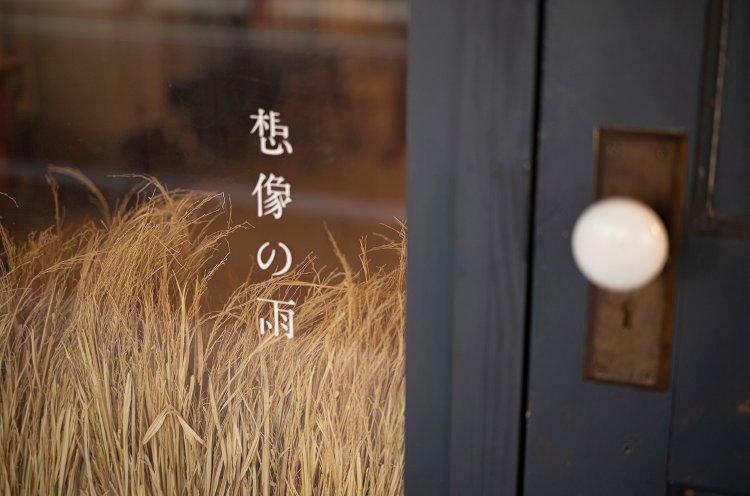 「晴耕雨読」を表現した藁のオブジェが、通りからも目を引く。店の青い扉はフランスのアンティークだ。