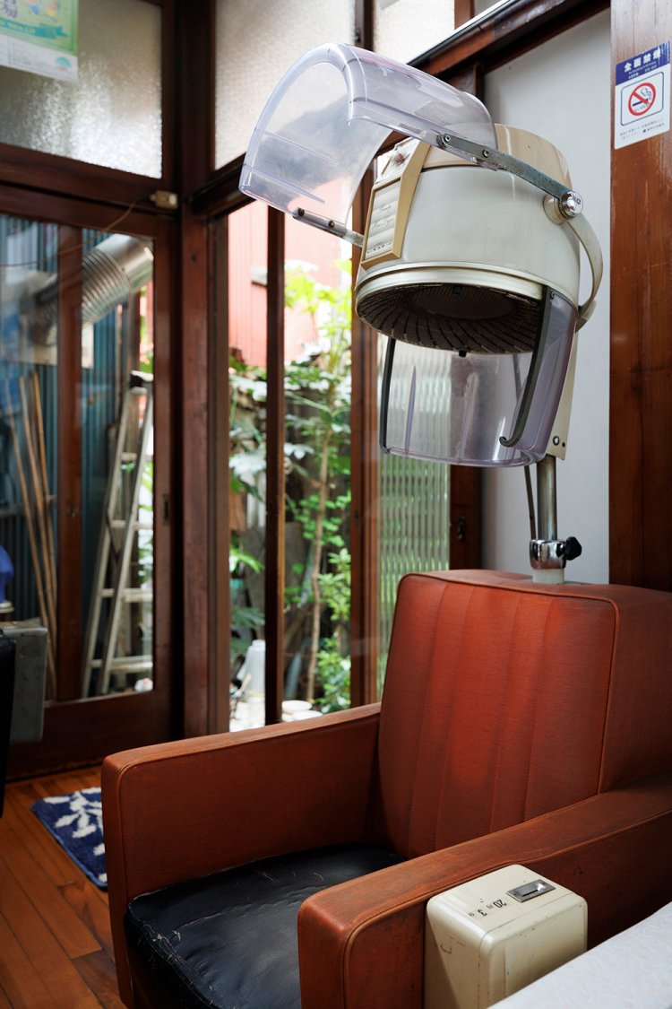 年代物のお釜ドライヤーやマッサージ機、アントニオ猪木のサインなどが、レトロ感を高める。