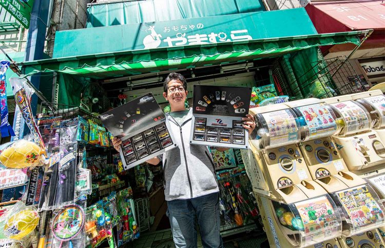 トミカのプレミアムシリーズを持つ山村さん。