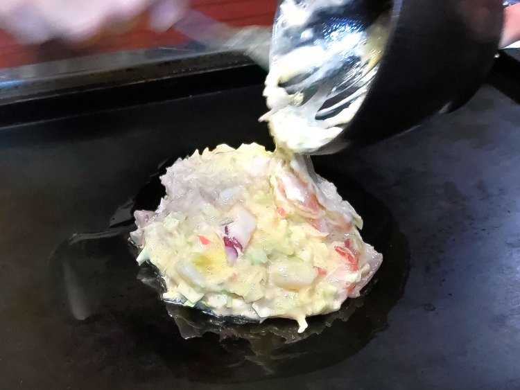 生地の具材をよくかき混ぜてから、油をひいた鉄板へ。厚さは、好みに合わせて調整を。