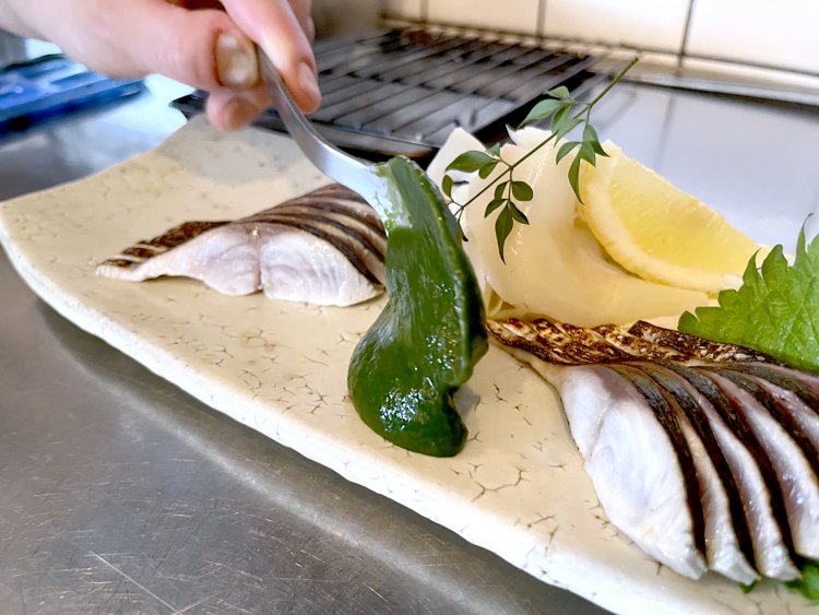 鮮やかな緑色で、ぽってりとした春菊醤油のソース。これを〆鯖につけて食べるのだ。