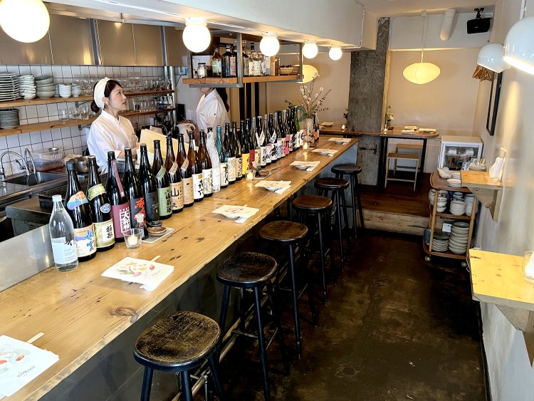 入り口からすぐのところにカウンター席や立ち飲みスペース、奥にはテーブル席も完備。