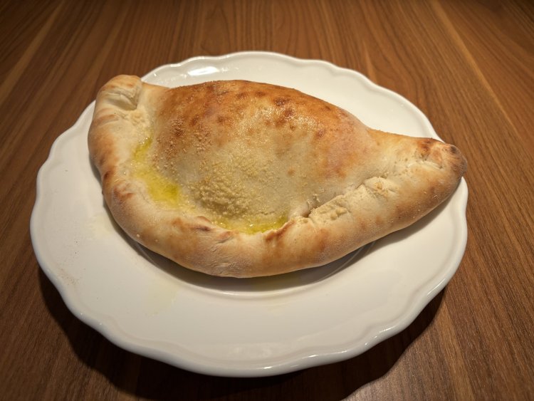 濃厚な卵とチーズ、酸味のあるトマトソースが入った名物包み焼きピッツァ「カルツォーネ」1000円。