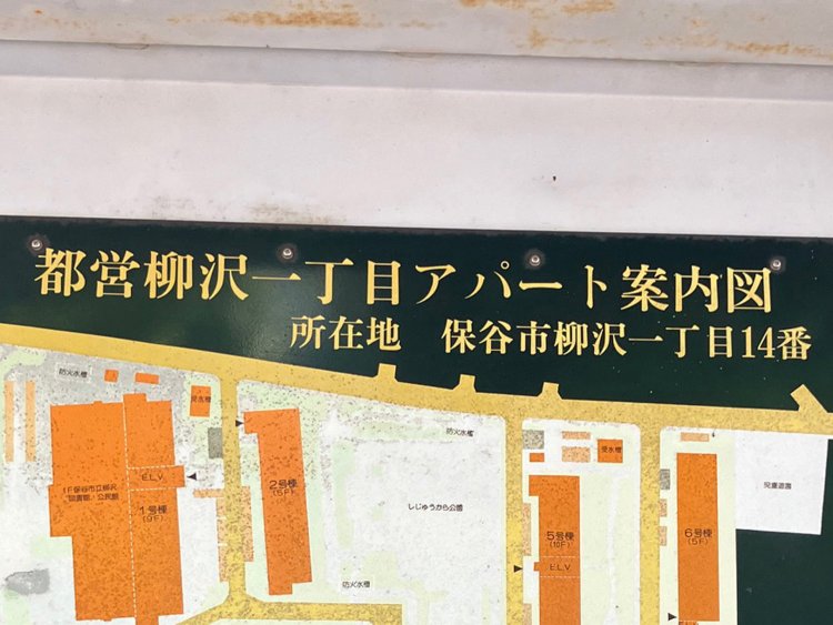 西武柳沢駅前の団地看板。この深緑色の背景に合わせて文字を修正するのは難しそうである。