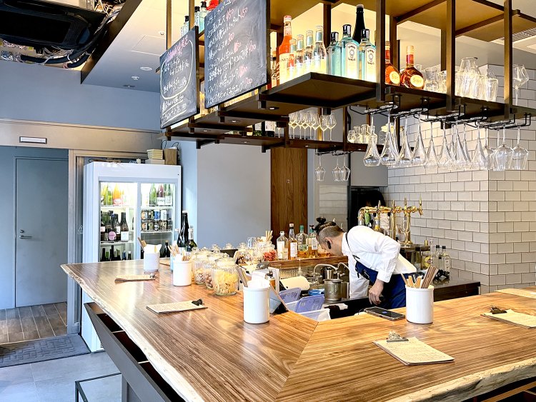 コの字のカウンターは高級感のある1枚板。キッチンを囲みながらわきあいあいとお酒が楽しめる。