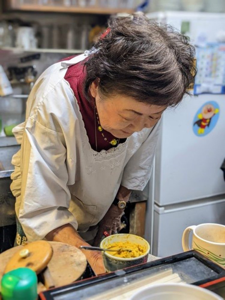 白割烹着姿の女将さん。