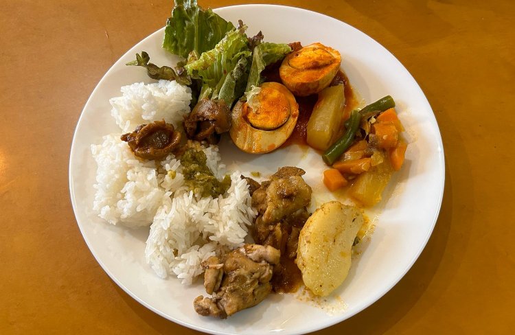 お皿にのせるのは食べられる分だけ！たまごのトマト煮、大根や人参などの煮込み、チェッターヒェン、米を選んだ。