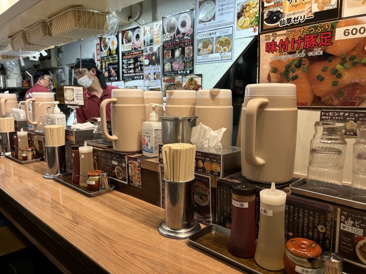 活気あふれるカウンター席。味変用の調味料が並ぶ。