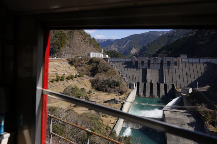 急勾配の眼下には長島ダム。遠くには移設前の線路敷設箇所が見える。